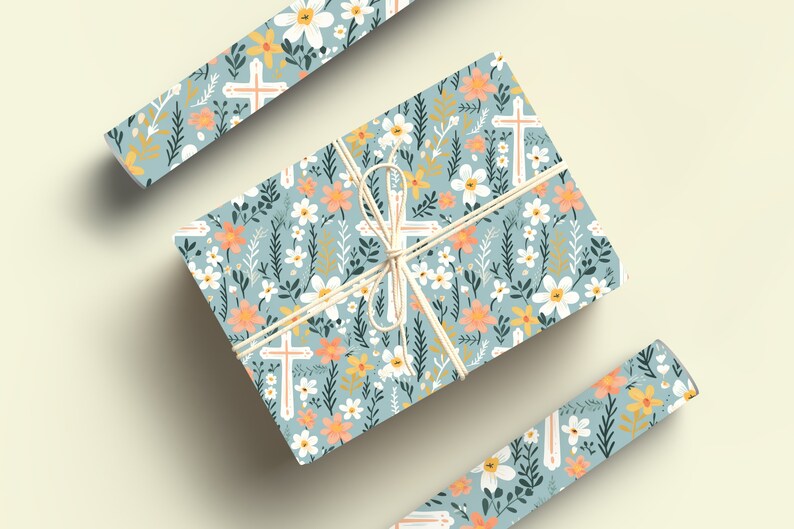 May include: A gift wrapped in blue floral wrapping paper with white crosses and a light brown twine bow. The paper features a repeating pattern of white flowers, orange flowers, green leaves, and white crosses.