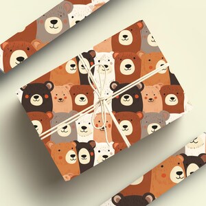 Op de afbeelding: Een bruin en wit cadeaupapier met een herhalend patroon van beren gezichten. De beren zijn in verschillende kleuren, waaronder bruin, wit en zwart. Het papier is vastgebonden met een wit touwtje.