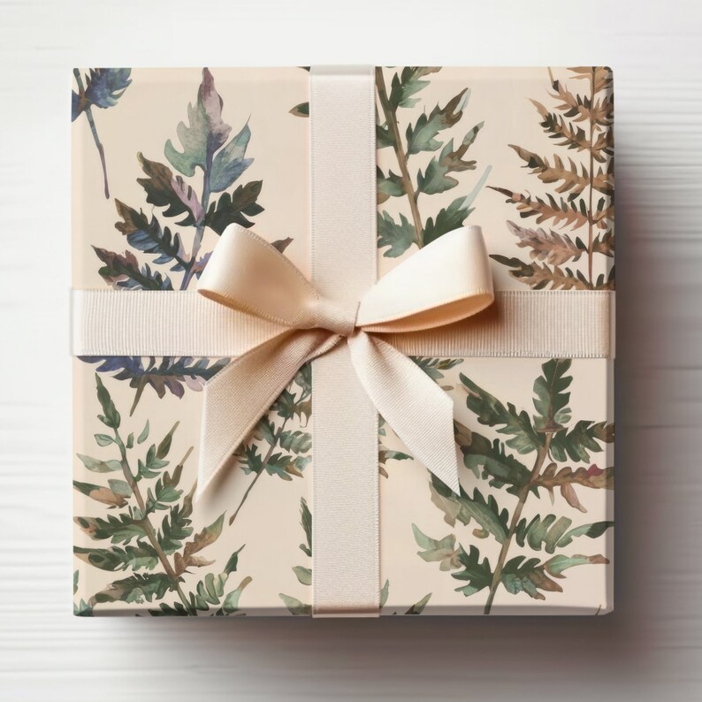 May include: A gift box wrapped in beige paper with a watercolor fern pattern and tied with a cream-colored satin ribbon.