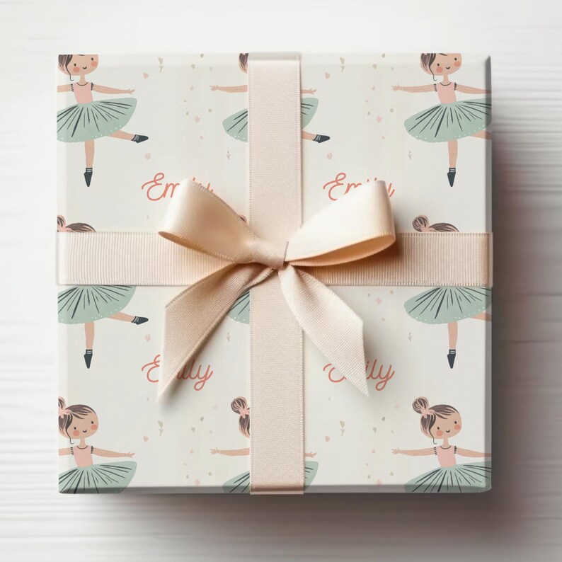 May include: A white gift box with a pink and green ballerina pattern. The box is wrapped with a beige ribbon and bow. The text "Emily" is repeated on the box.