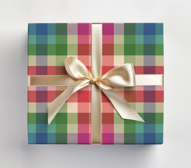 May include: A square gift box wrapped in colorful plaid paper. The plaid pattern features a mix of blue, green, red, and pink squares. A cream-colored satin ribbon is tied in a bow on top, adding a touch of elegance to the present.