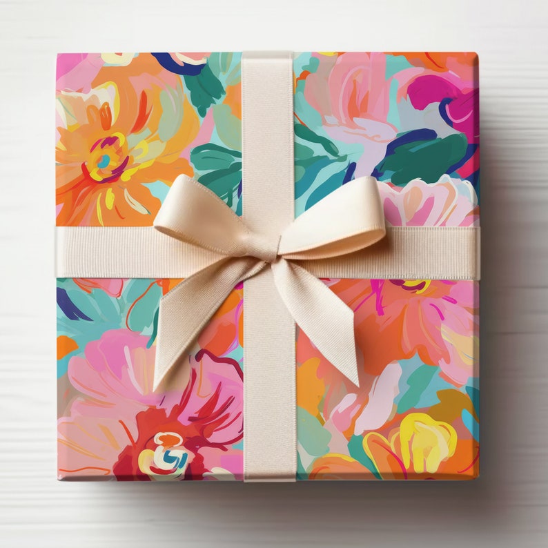 May include: A gift box wrapped in colourful floral patterned paper with a cream-coloured ribbon tied in a bow.