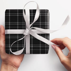 May include: A black and white plaid gift box with a white satin ribbon tied in a bow.