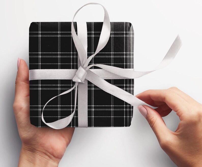 May include: A black and white plaid gift box with a white satin ribbon tied in a bow.