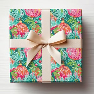 May include: A gift box wrapped in teal blue wrapping paper with a pink and orange floral pattern. The box is tied with a cream-coloured ribbon.