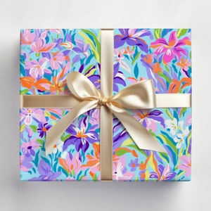 May include: A gift box wrapped in blue floral patterned paper with a gold ribbon tied in a bow.
