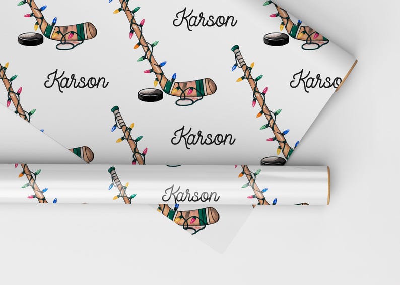 K&ouml;nnte beinhalten: Wei&szlig;es Geschenkpapier mit einem sich wiederholenden Muster aus Hockeyschl&auml;gern mit Weihnachtslichtern und dem Namen "Karson".