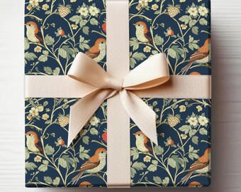 Könnte beinhalten: Eine marineblaue Geschenkbox mit einem cremefarbenen Band. Die Box ist mit Papier umwickelt, das ein sich wiederholendes Muster aus Vögeln, Blumen und Erdbeeren zeigt.