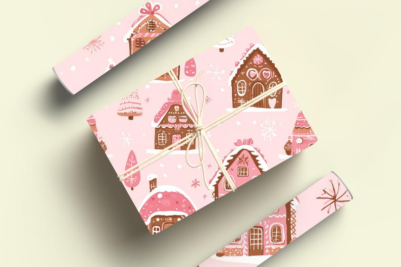 May include: Pink wrapping paper with a repeating pattern of gingerbread houses and Christmas trees. The houses are decorated with pink icing and candy.
