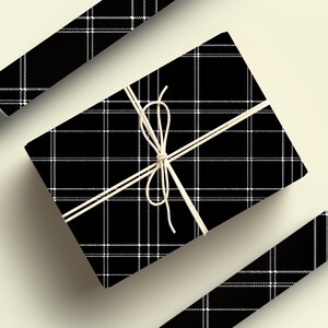 May include: A black and white plaid gift box tied with twine. The box is wrapped in a black and white plaid pattern.