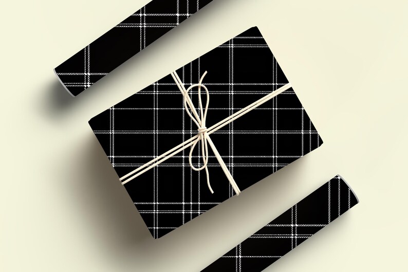 May include: A black and white plaid gift box tied with twine. The box is wrapped in a black and white plaid pattern.