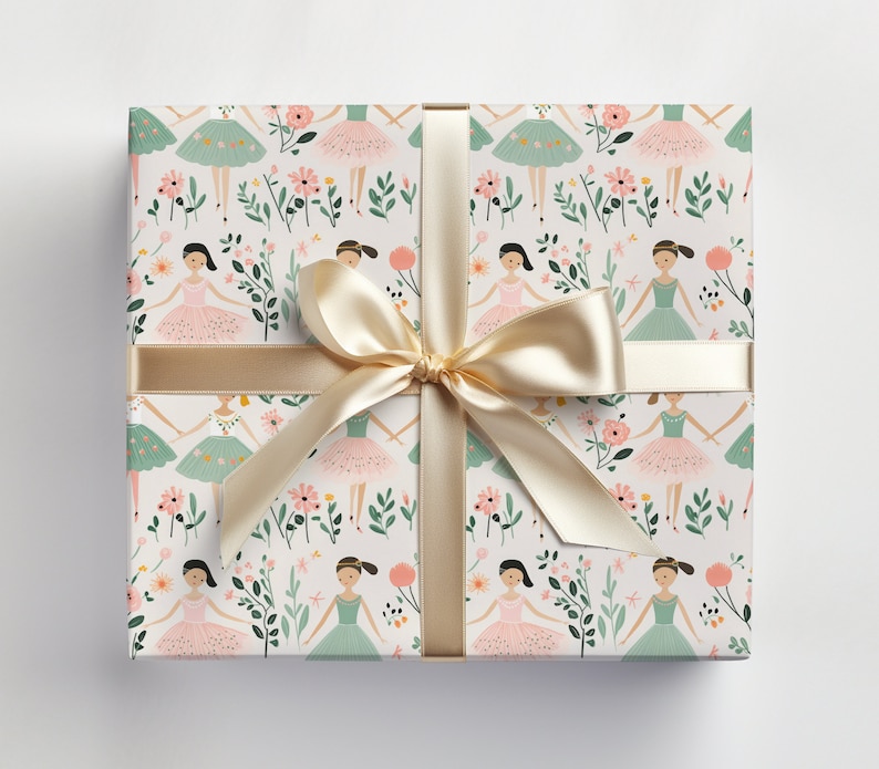 May include: A white gift wrap with a repeating pattern of pink and green ballerina figures with flowers and leaves. The gift wrap is tied with a gold ribbon.