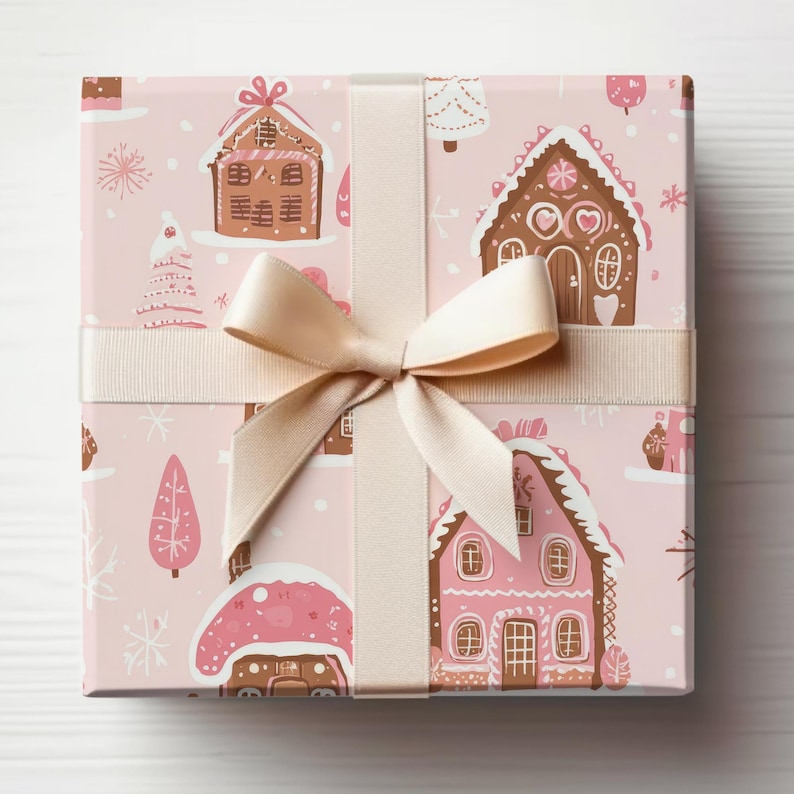 May include: A pink gift box with a beige ribbon and bow. The box is wrapped in paper with a pattern of gingerbread houses, candy canes, and snowflakes.