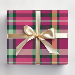 May include: A pink, green, and cream plaid gift box with a gold satin ribbon tied in a bow.