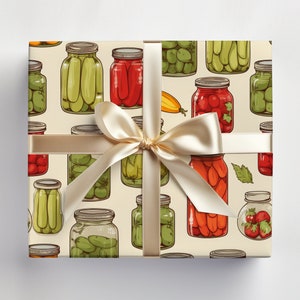 May include: A cream-colored gift wrap with a repeating pattern of various jars of pickled vegetables and fruits. The jars are filled with green peppers, red peppers, tomatoes, and cucumbers. A beige ribbon is tied around the gift wrap.