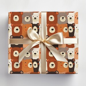Op de afbeelding: Cadeaupapier met een herhalend patroon van bruine, witte en zwarte beren met verschillende gezichtsuitdrukkingen. De beren zijn willekeurig gerangschikt op een cr&egrave;mekleurige achtergrond.