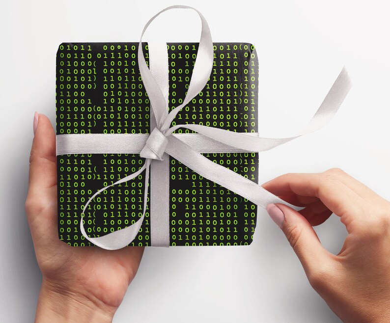Peut inclure: Un cadeau emball&eacute; avec un fond noir recouvert d'un code binaire vert. Le cadeau est nou&eacute; avec un ruban de satin blanc, formant un n&oelig;ud. Le cadeau est tenu par deux mains.