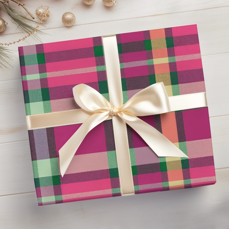 May include: A pink and green plaid gift box with a cream-colored satin ribbon tied in a bow.