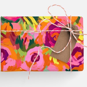 May include: A gift box wrapped in pink and orange floral patterned paper with a brown gift tag tied with white and pink twine.