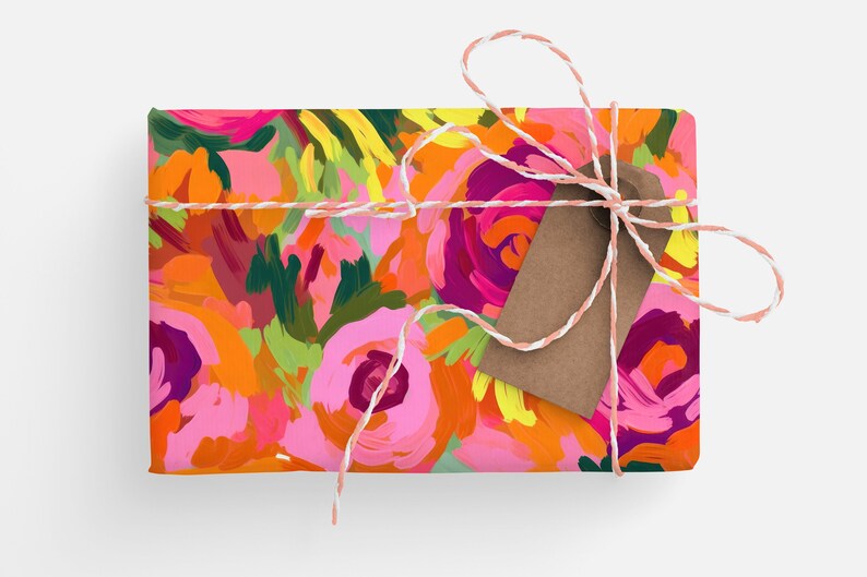 May include: A gift box wrapped in pink and orange floral patterned paper with a brown gift tag tied with white and pink twine.
