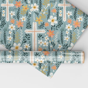 May include: A roll of blue wrapping paper with a floral pattern featuring white flowers, green leaves, and orange and yellow accents. The pattern also includes white crosses.