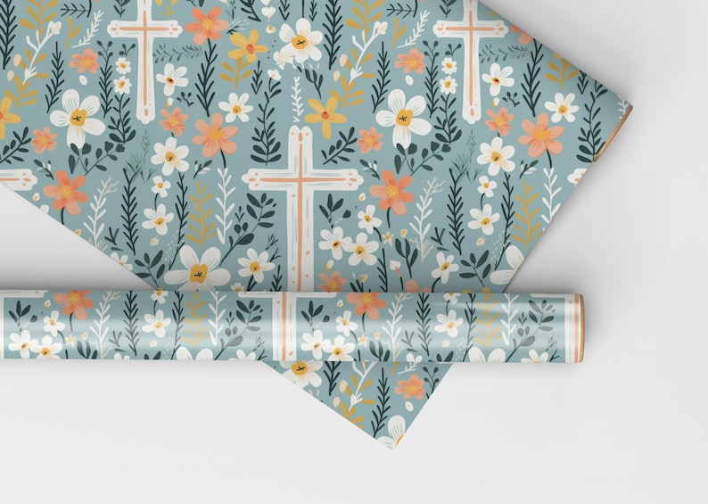 May include: A roll of blue wrapping paper with a floral pattern featuring white flowers, green leaves, and orange and yellow accents. The pattern also includes white crosses.