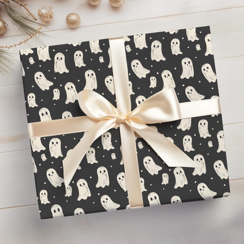May include: Black gift wrap with a white ghost pattern and a cream-coloured ribbon tied in a bow.