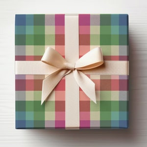 May include: Square gift box wrapped in colorful plaid paper with a cream-colored ribbon and bow. The plaid pattern features squares of blue, green, pink, and beige. The bow is centered on the top of the box.