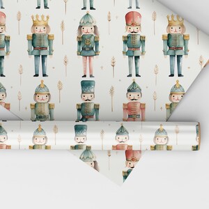 May include: White wrapping paper with a repeating pattern of watercolor nutcracker soldiers. The nutcrackers are wearing blue, red, and green uniforms with gold accents. The background is white with gold stars and small sprigs.