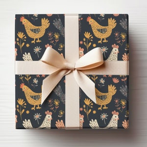 May include: A gift box wrapped in dark blue wrapping paper with a repeating pattern of yellow chickens and white flowers. The box is tied with a cream-colored ribbon.