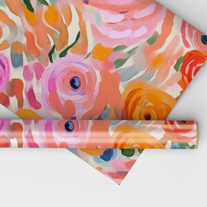 May include: A roll of wrapping paper with a floral pattern. The paper features pink, orange, and green flowers on a white background.