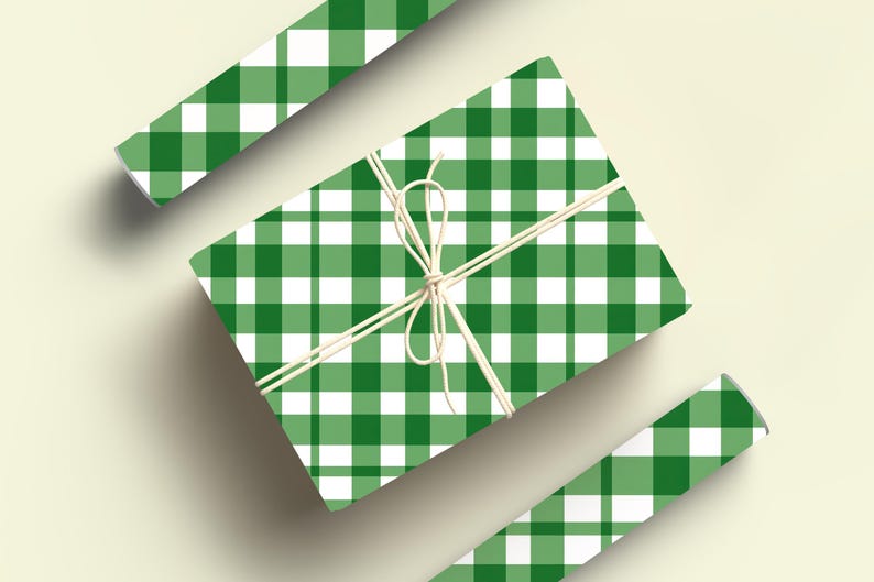 May include: Green and white gingham wrapping paper with a white ribbon tied around it. The paper is folded in half and the ribbon is tied in a bow.