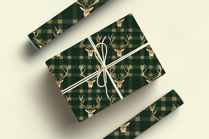 May include: Green and beige plaid wrapping paper with a gold stag head pattern. The paper is wrapped around a gift box and tied with twine.