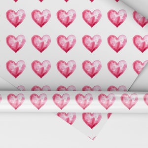 May include: Pink watercolor hearts on a white background. This wrapping paper features a repeating pattern of hearts.