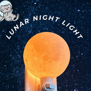 Peut inclure: Une veilleuse blanche en forme de lune orange brillante avec le texte "LUNAR NIGHT LIGHT" au-dessus, sur un fond bleu foncé avec des étoiles blanches.