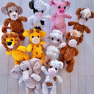 May include: A collection of ten crocheted animal keychains. The keychains are made of soft, colourful yarn and feature a variety of animals, including a lion, a monkey, a cow, a pig, a horse, a giraffe, an elephant, and a sheep.