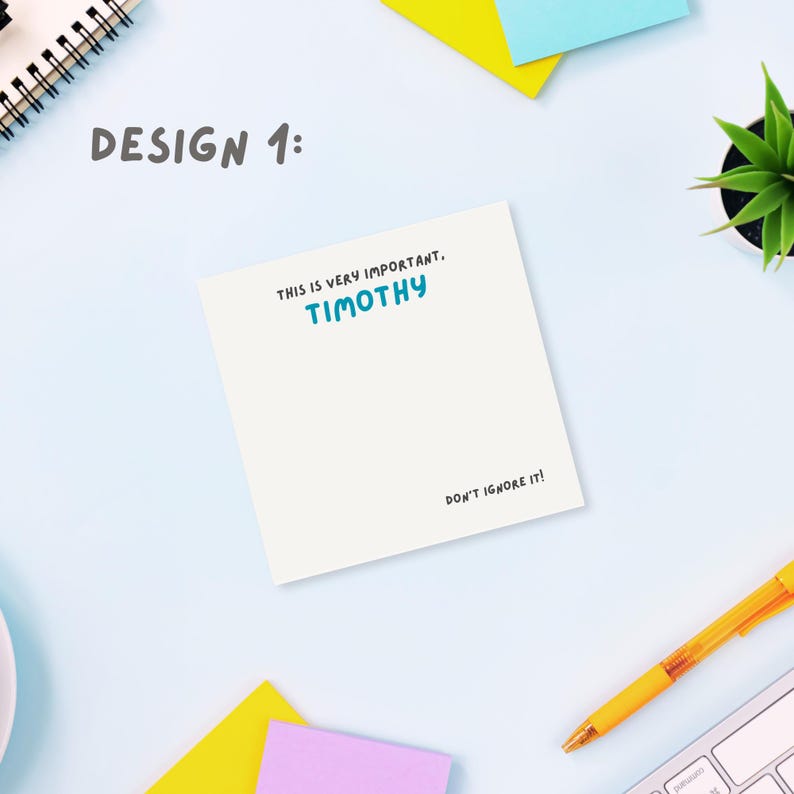 Op de afbeelding: Een wit notitieblok met de tekst "Dit is erg belangrijk. TIMOTHY. Negeer het niet!" erop gedrukt. Het notitieblok ligt op een lichtblauw oppervlak met een gele en roze sticky note, een plant in een pot en een gele pen.