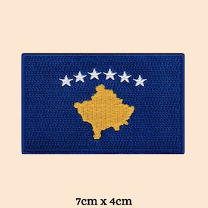 May include: A blue embroidered patch with the flag of Kosovo. The flag features a gold outline of the country's shape and six white stars in a circle.