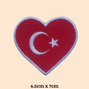 May include: Red heart-shaped patch featuring a white crescent moon and star, representing the Turkish flag. The patch measures 6.5 cm by 7 cm.