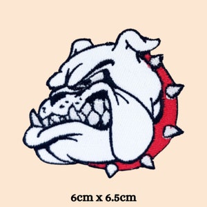 May include: White embroidered bulldog patch with a red spiked collar. The bulldog has a fierce expression with bared teeth. The patch measures 6 cm by 6.5 cm.
