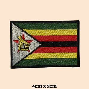 Könnte beinhalten: Gestickter Aufnäher mit der Flagge von Simbabwe. Der rechteckige Aufnäher hat einen schwarzen Rand und zeigt das Design der Flagge: grüne, gelbe, rote und schwarze horizontale Streifen, ein weißes Dreieck mit einem goldenen Vogel und einem roten Stern. Misst 4cm x 3cm.