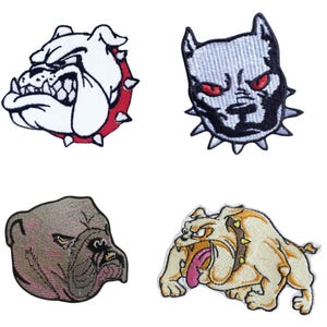 May include: Four embroidered bulldog patches. The patches depict bulldog faces in various colours, including white, grey, and tan. Each patch has a unique expression and style, with details such as spiked collars and open mouths.