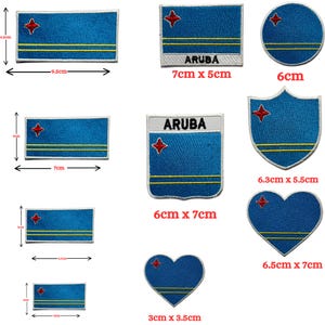 May include: A collection of embroidered patches featuring the Aruba flag design in various shapes including rectangles, circles, shields, and hearts. The patches are blue with yellow stripes and a red star, with some labeled with the text ARUBA.