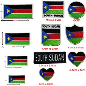 May include: A collection of embroidered patches featuring the South Sudan flag in various shapes including rectangles, circles, shields, and hearts. Some patches include the text SOUTH SUDAN. Dimensions are provided in centimeters for each item.