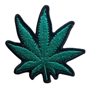 Puede incluir: Parche bordado con una hoja de cannabis verde con costuras detalladas. La hoja está delineada en negro, creando un borde definido. Este parche está diseñado para su aplicación en ropa o accesorios.