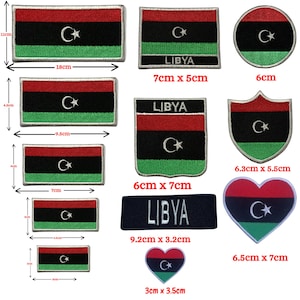 May include: A collection of embroidered patches featuring the flag of Libya with red, black, and green horizontal stripes and a white crescent and star. Various shapes include rectangles, circles, shields, and hearts, with dimensions ranging from 3cm to 18cm.