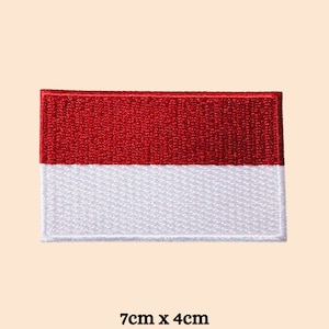 Op de afbeelding: Een rechthoekige patch met de Indonesische vlag, met een rode bovenste helft en een witte onderste helft. De patch meet 7 cm x 4 cm. De vlag is geborduurd met een getextureerde uitstraling.