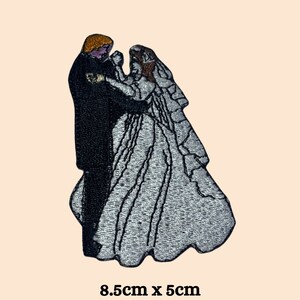 May include: Embroidered iron-on patch of a bride and groom dancing, 8.5 cm by 5 cm.