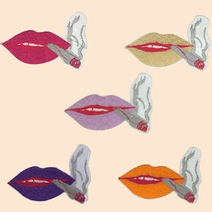 May include: Five embroidered iron-on patches featuring a red mouth with a white cigarette and smoke coming out of it. The patches are in different colors: pink, beige, purple, orange, and blue.
