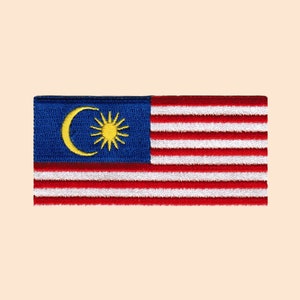 May include: A yellow embroidered patch of the Malaysian flag. The flag is blue with a yellow crescent moon and a 14-pointed star. The bottom portion of the flag is red and white stripes.